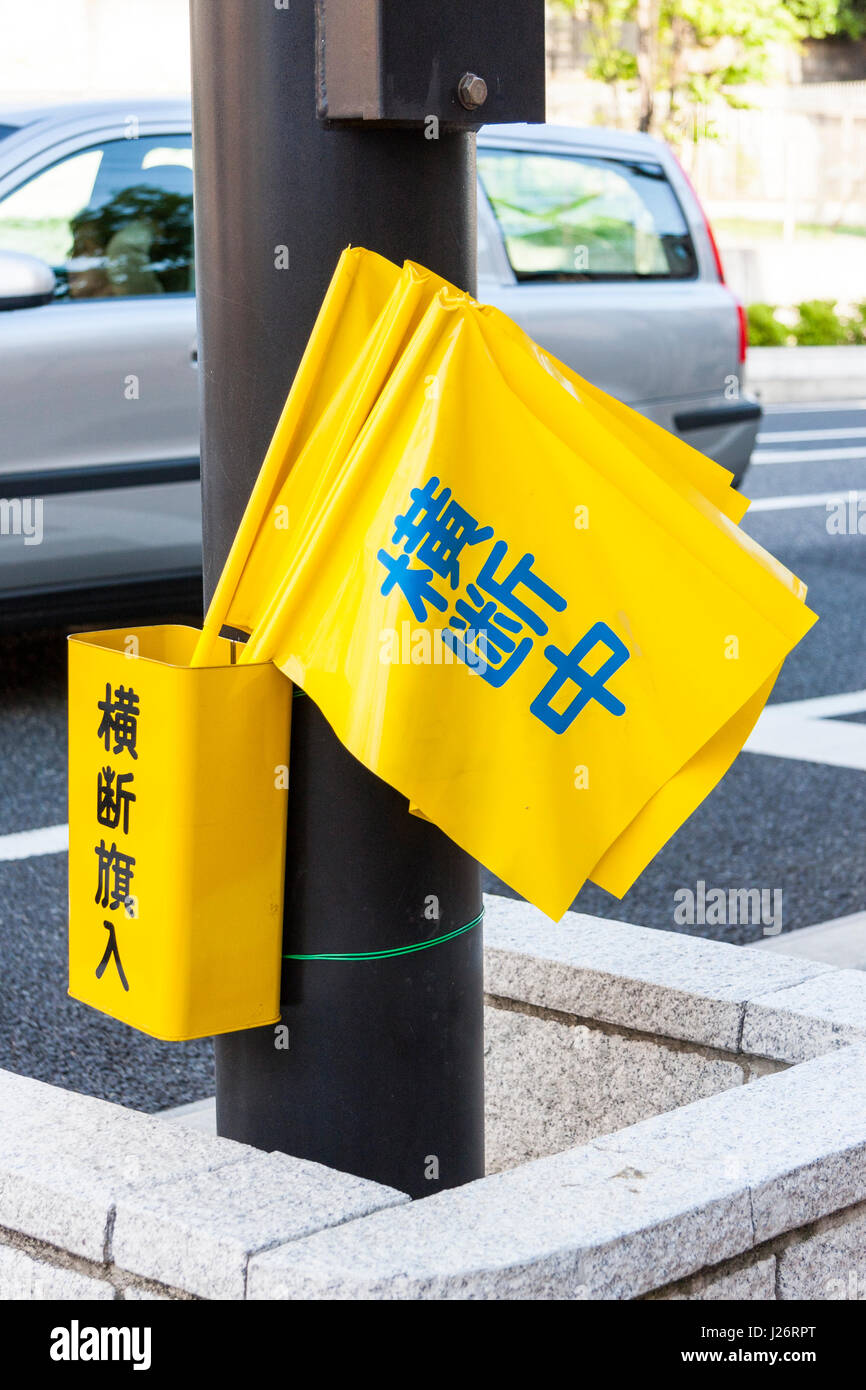 Le Japon. Drapeaux jaunes dans la benne par des feux de circulation, utilisés par les parents, les enseignants et les enfants pour arrêter le trafic afin d'autres enfants peuvent traverser. Banque D'Images