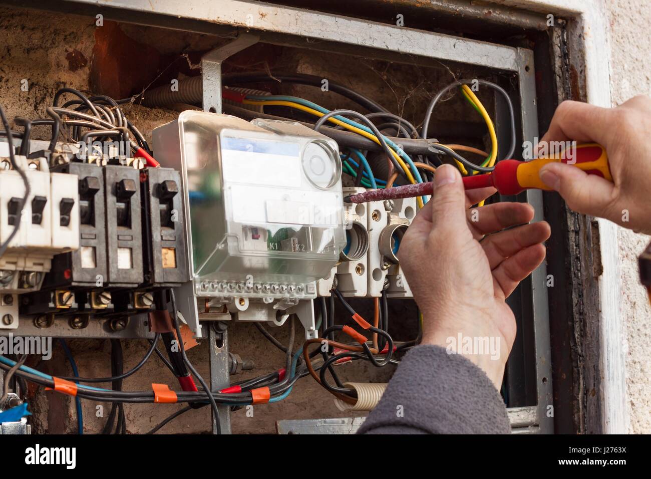 La réparation de vieux appareils de commutation électrique. Un électricien remplace l'ancien appareils électriques Banque D'Images