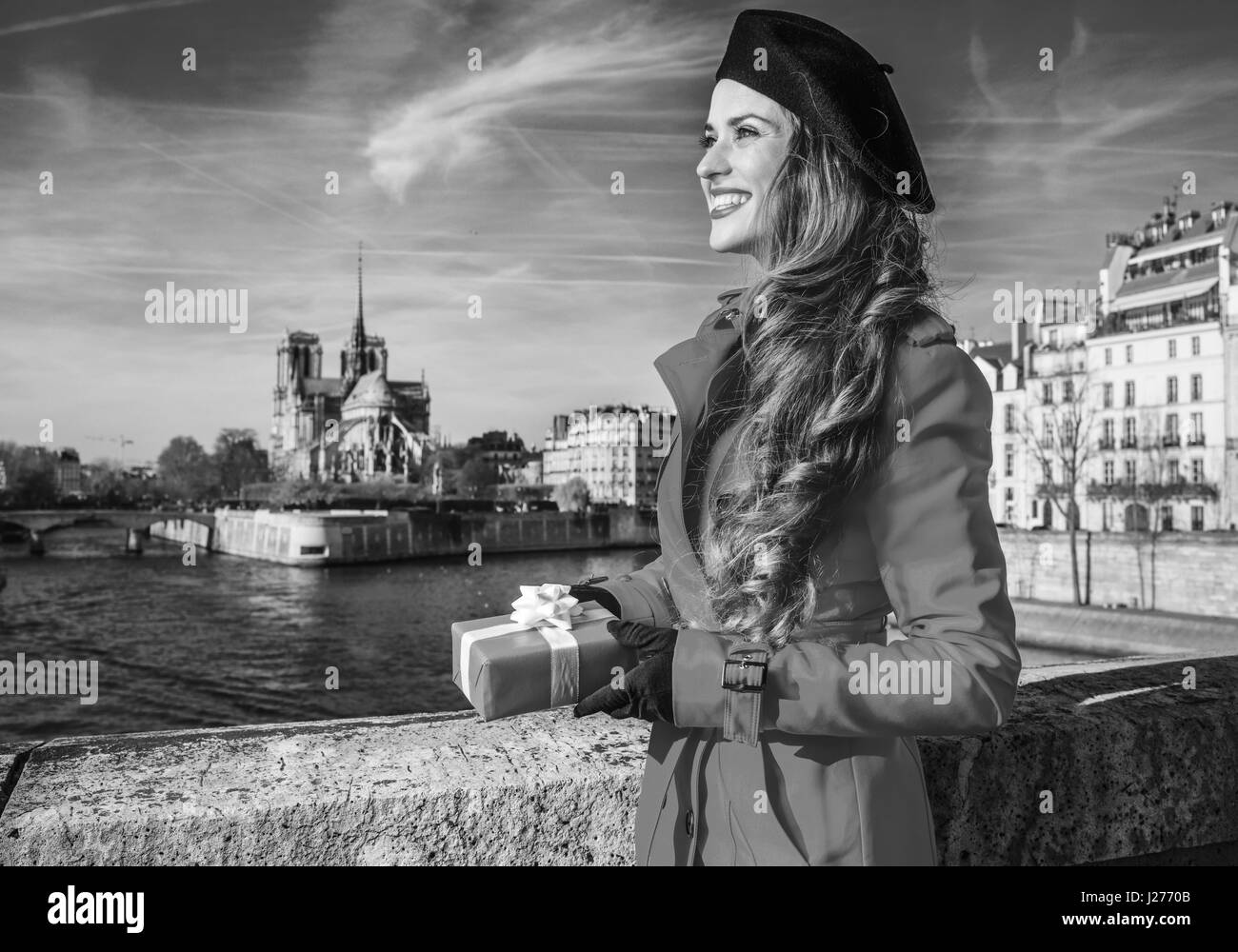 Brillante dans Paris. bonne femme élégante en trench-coat rouge sur le quai  à Paris, France avec cadeau de Noël fort à la recherche dans la distance  Photo Stock - Alamy
