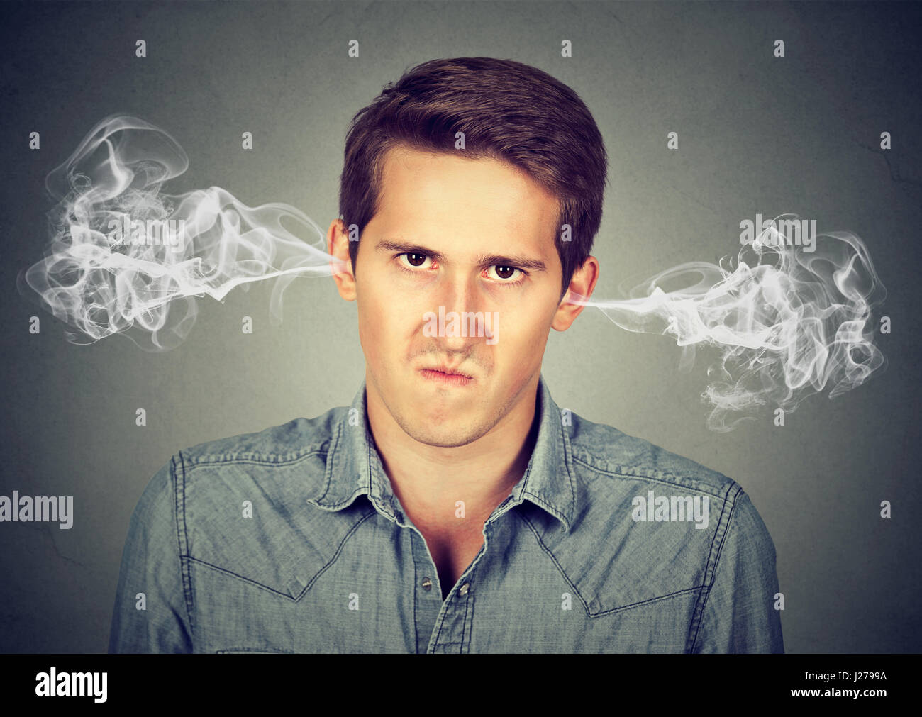 Closeup portrait de jeune homme en colère, soufflant de la vapeur qui sort des oreilles, à propos d'avoir isolé nerveuse fond gris. Les droits de l'emotio négatif Banque D'Images