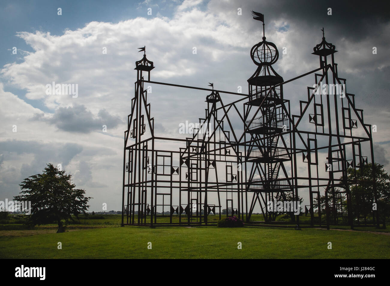 Ossature structure bâtie sur grassy field against cloudy sky Banque D'Images