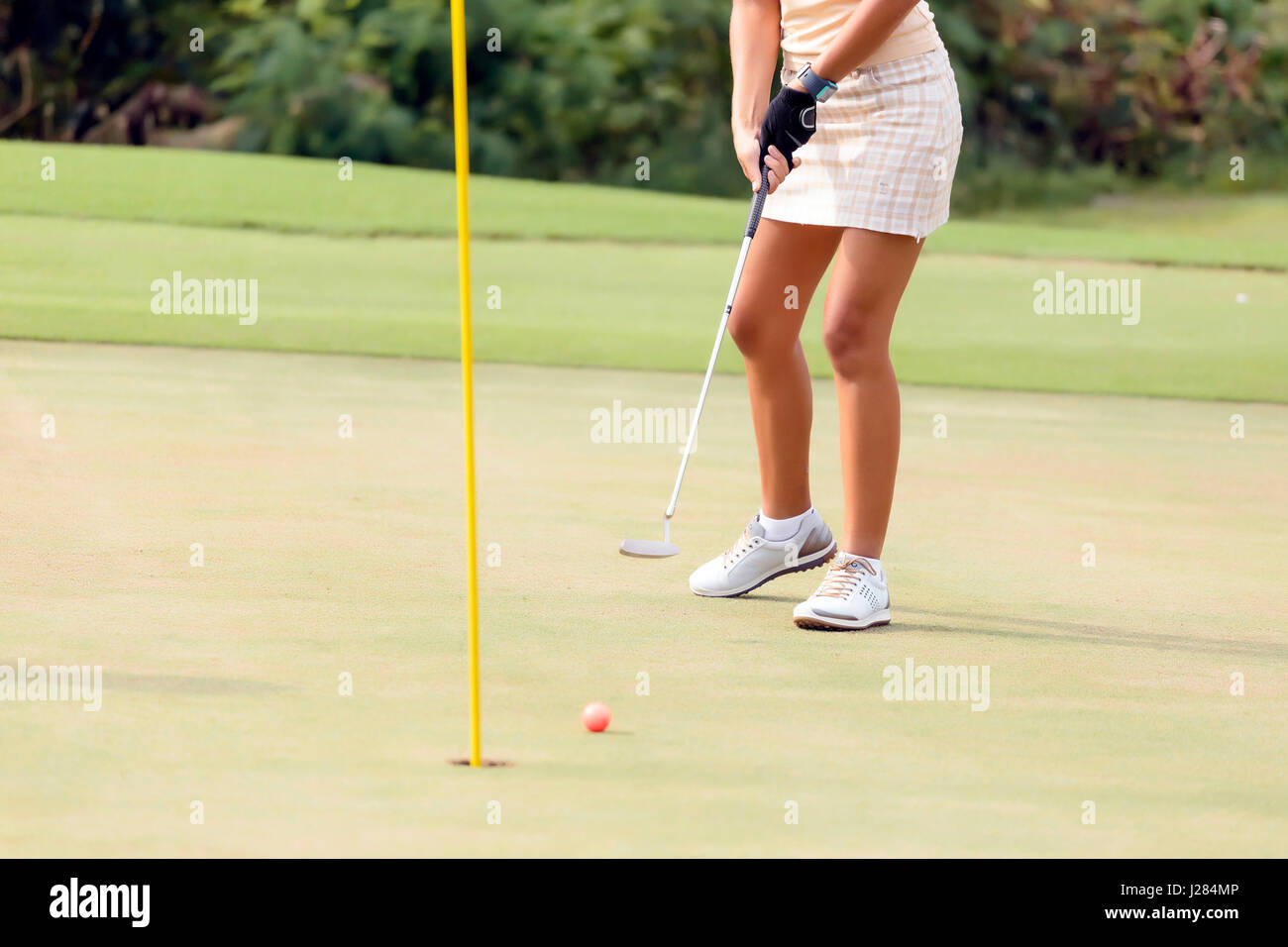 La section basse de femme jouant au golf au terrain de golf Banque D'Images