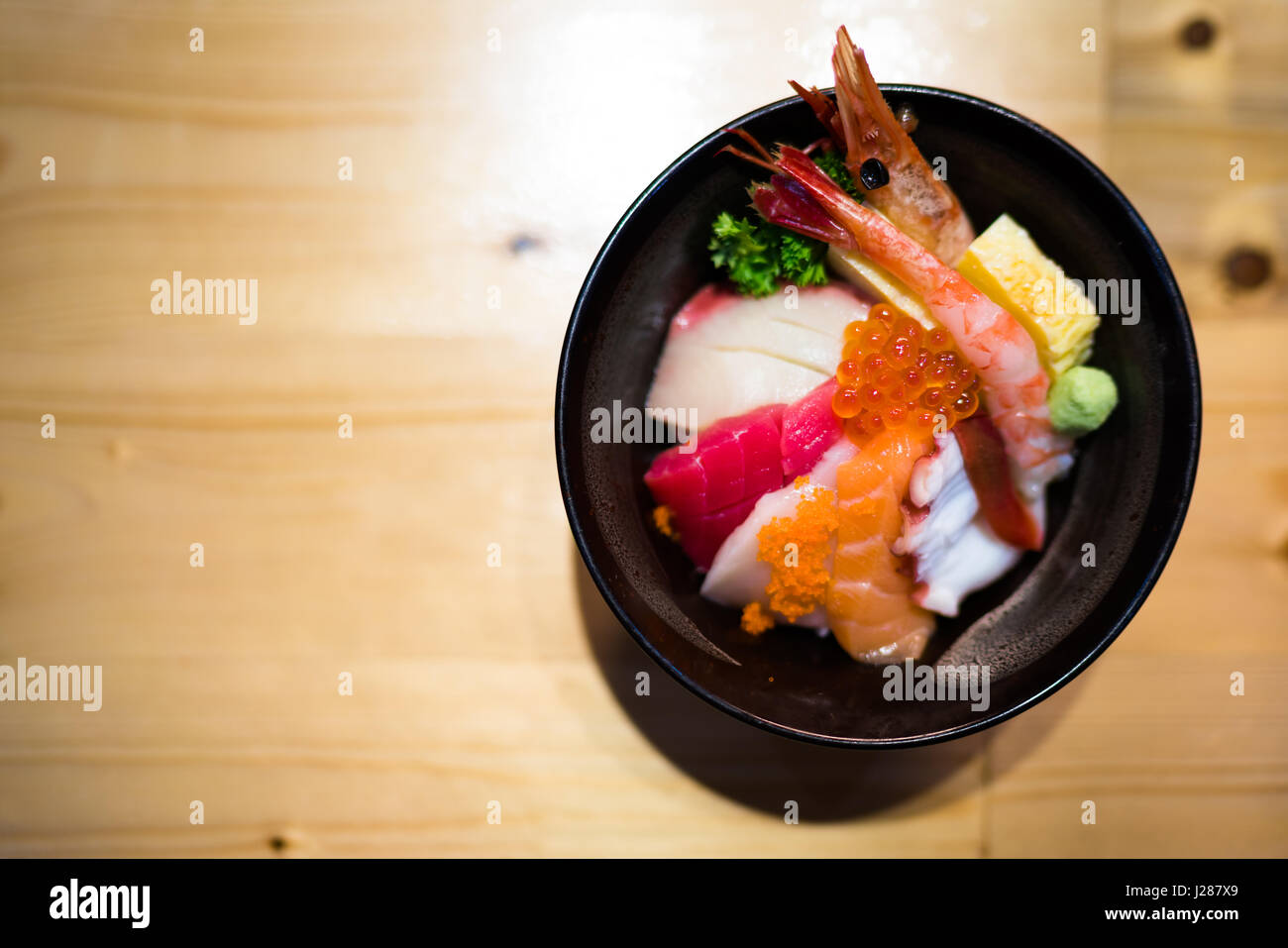 Chirashi sushi, nourriture japonaise bol de riz avec matières Sashimi au saumon, fruits de mer, vue du dessus, assombrir edge, copie de l'espace sur une table en bois, l'accent sur des oeufs de saumon Banque D'Images
