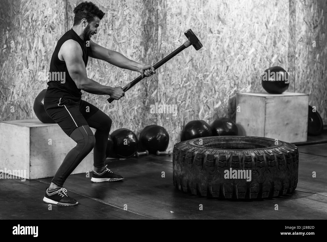 Remise en Forme Sport homme frapper avec un marteau pneumatique de roue d'entraînement Crossfit traîneau, les jeunes de l'intérieur de sport Guy sain Banque D'Images