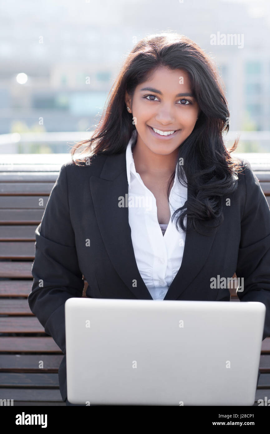 Un coup d'un Indian businesswoman working on her laptop outdoor Banque D'Images