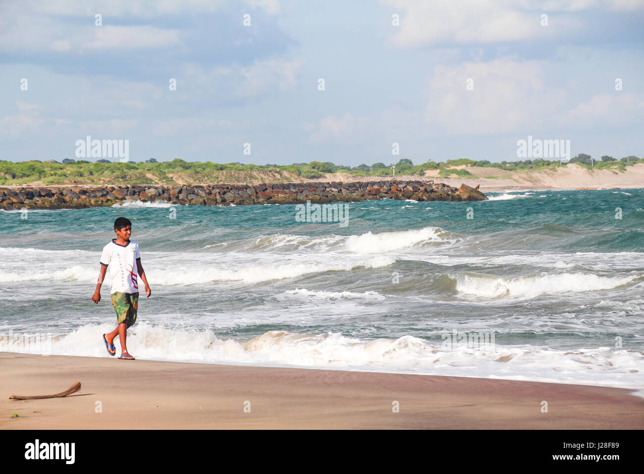 Sri Lanka, dans la Province du Sud, Kirinda, Cingalais boy walking on the beach Banque D'Images