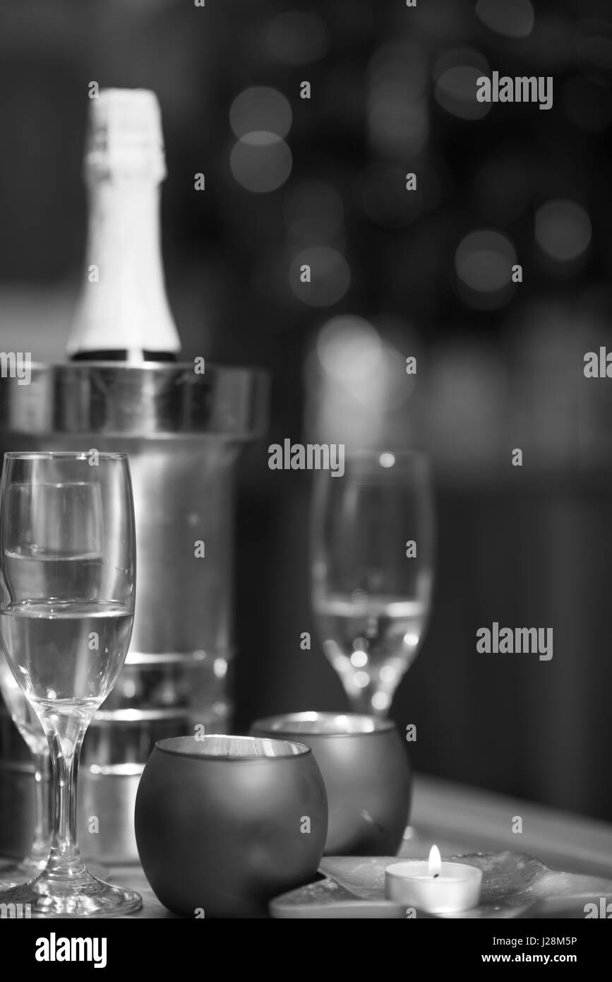 Champagne et verres de cristal sur une table en bois avec des bougies et des lumières de Noël dans l'arrière-plan Banque D'Images