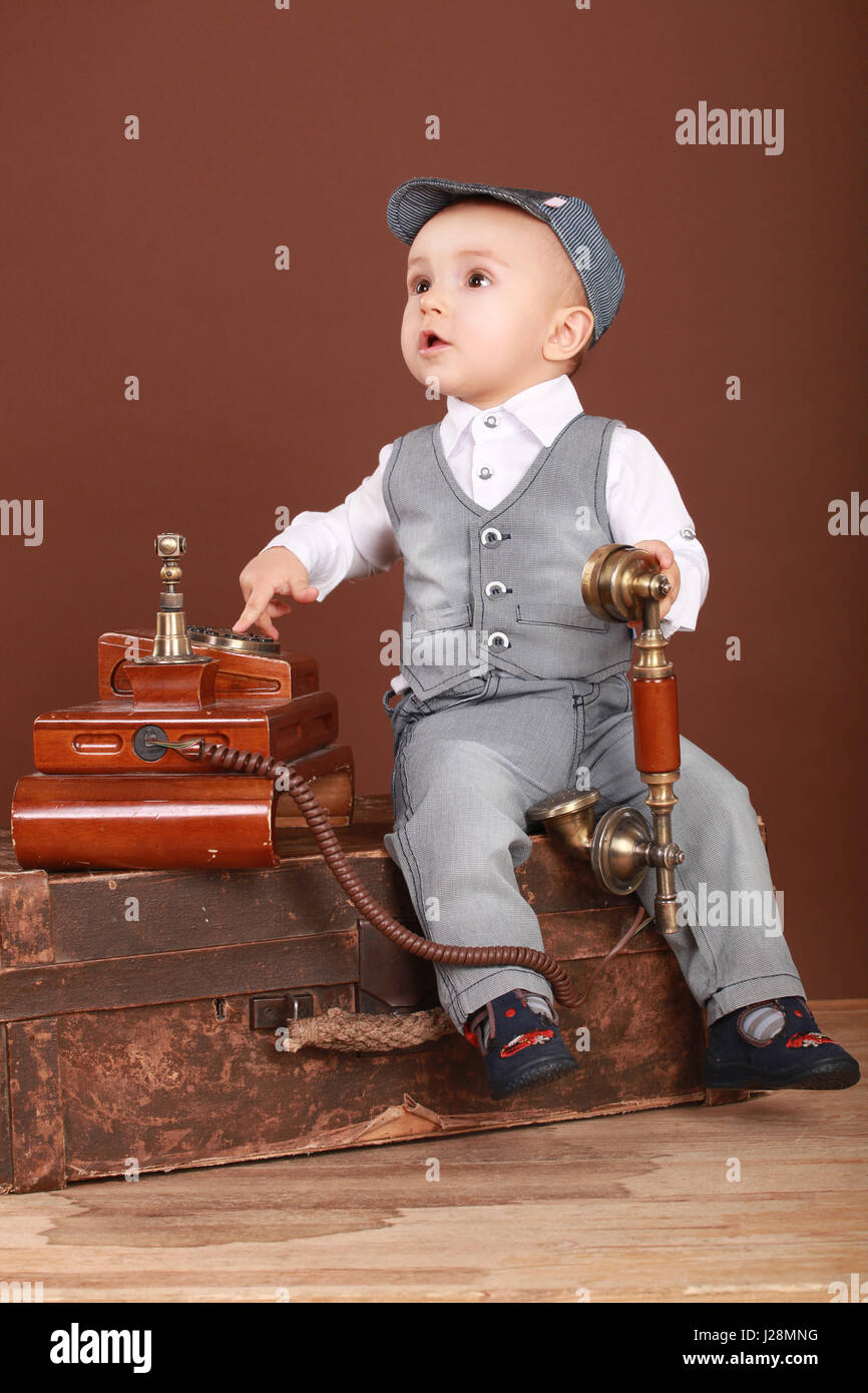 Mignon Bebe Assis Sur Une Valise Tenant Un Telephone Vintage Et Looking Up Photo Stock Alamy Mignon Bebe Assis Sur Une Valise Tenant Un Telephone Vintage Et Looking Up Photo Stock Alamy