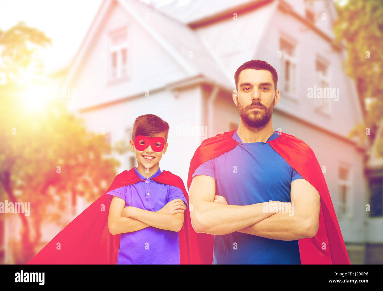 Man and boy wearing mask et cape de super-héros rouge Banque D'Images