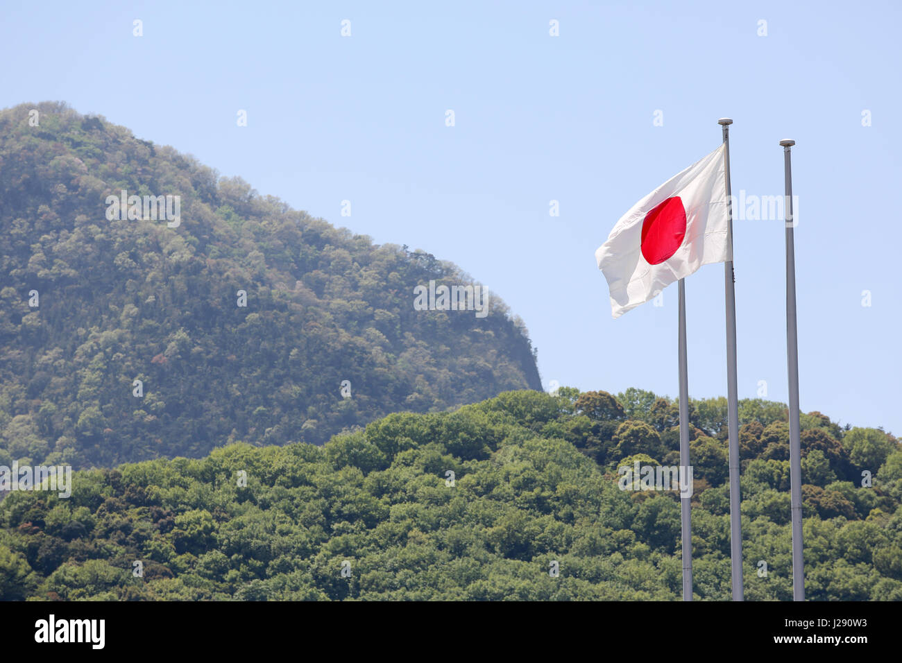 Drapeau japonais en vent contre ciel bleu clair Banque D'Images