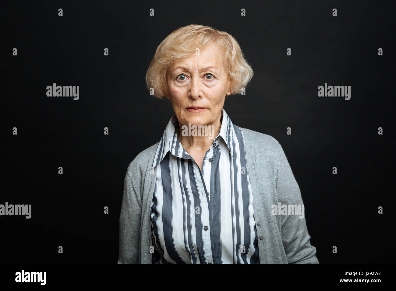 Resolute femme retraités à exprimer leur colère dans le studio de couleur noir Banque D'Images