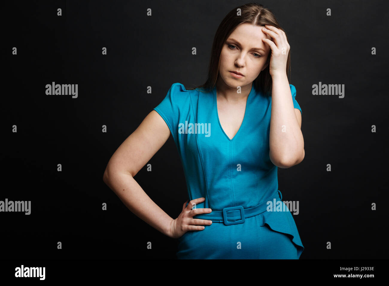 Jeune femme concentrée exprimant le désespoir dans le studio Banque D'Images