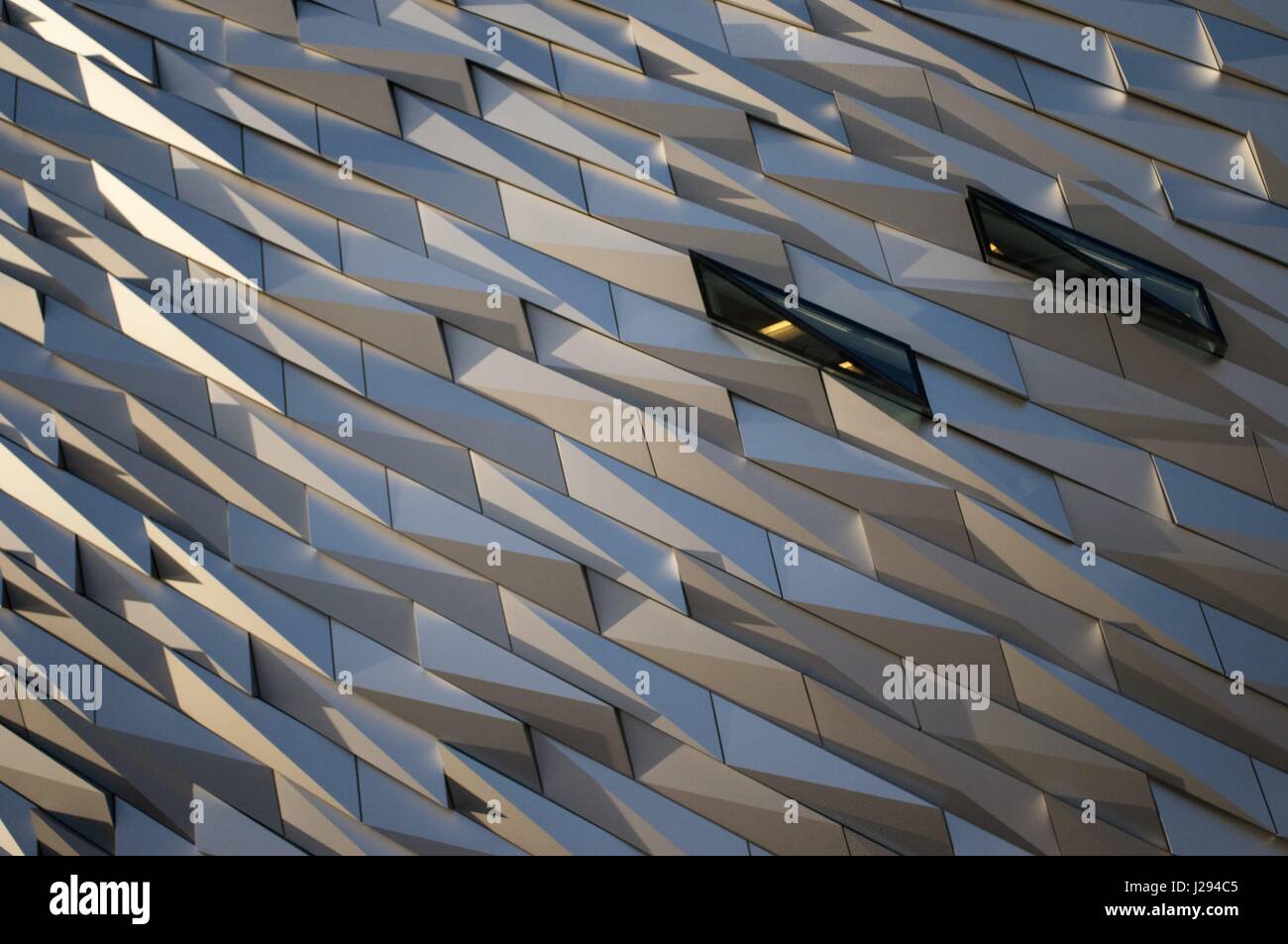 Titanic Belfast museum and Visitors Center, Titanic Quarter, Belfast, Irlande du Nord, Royaume-Uni. Le bâtiment est revêtu de débris de métal et quand la lumière joue sur eux, il semble que le mouvement de l'eau. À partir de ci-dessus, le bâtiment ressemble à une étoile blanche, symbole de l'opérateurs du Titanic. Novembre 2016 | Le monde d'utilisation Banque D'Images
