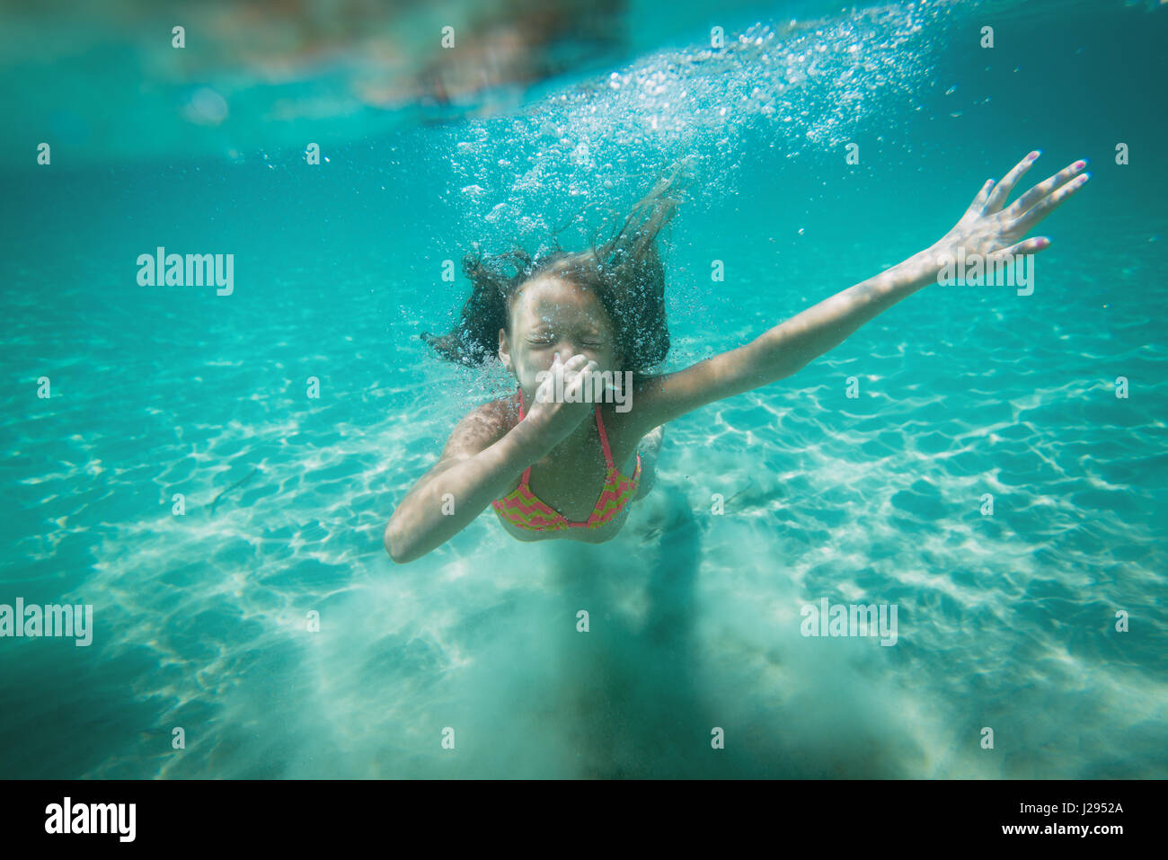 Belle petite fille plonger sous l'eau dans la mer. Elle tient son nez avec  la main et tenant breat Photo Stock - Alamy