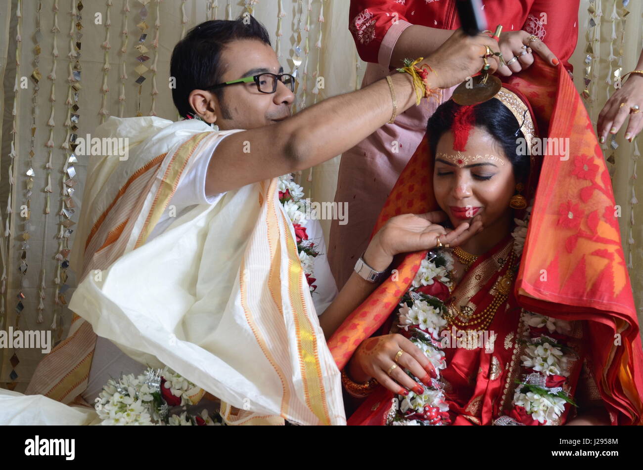 Le marié s'applique sindoor ou vermilion (un symbole du mariage porté par les femmes hindoues ensuite) sur les cheveux de la mariée-partition Banque D'Images