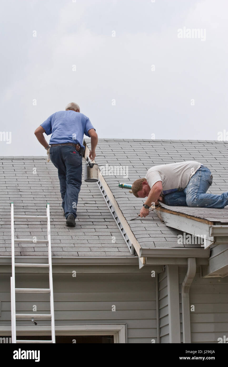 Les hommes faisant les réparations sur l'exterier d'une maison, l'élimination des bois pourris et résisté au besoin, Banque D'Images