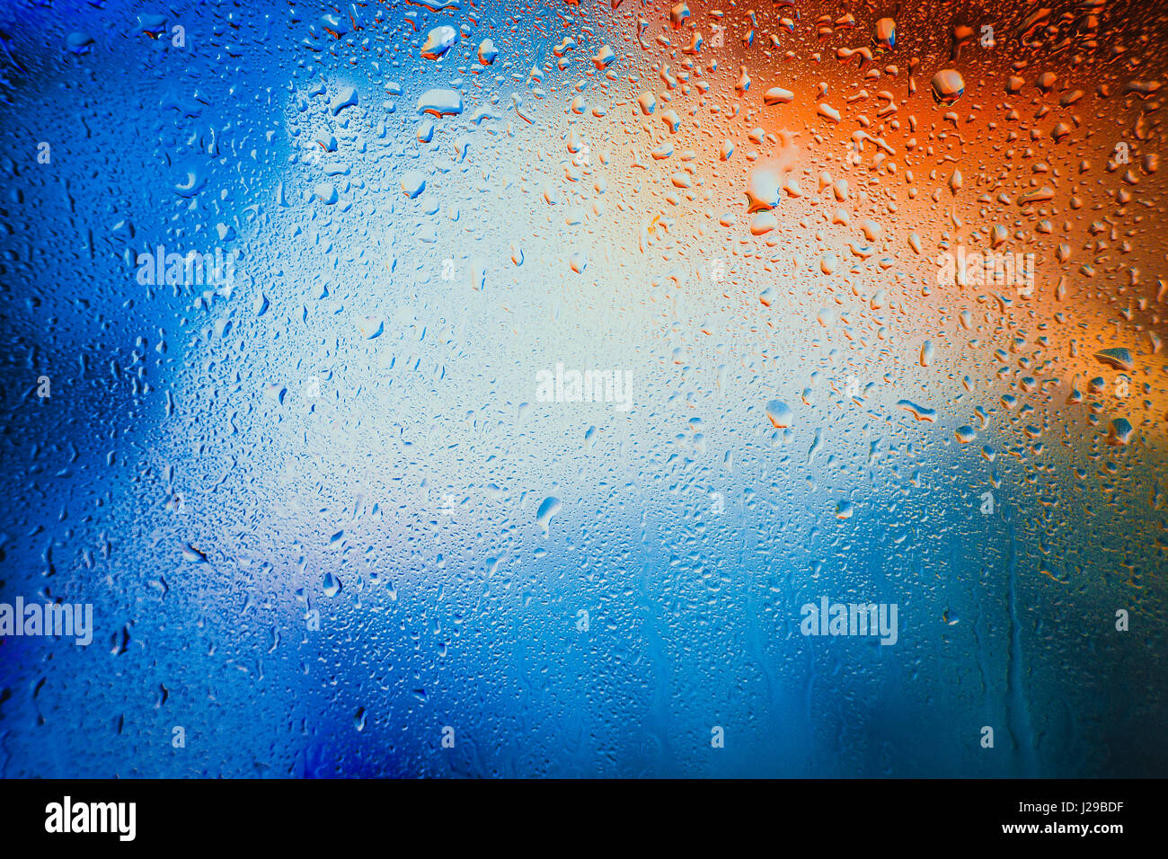 Gouttes de pluie sur un fond multicolore brouillée. Banque D'Images