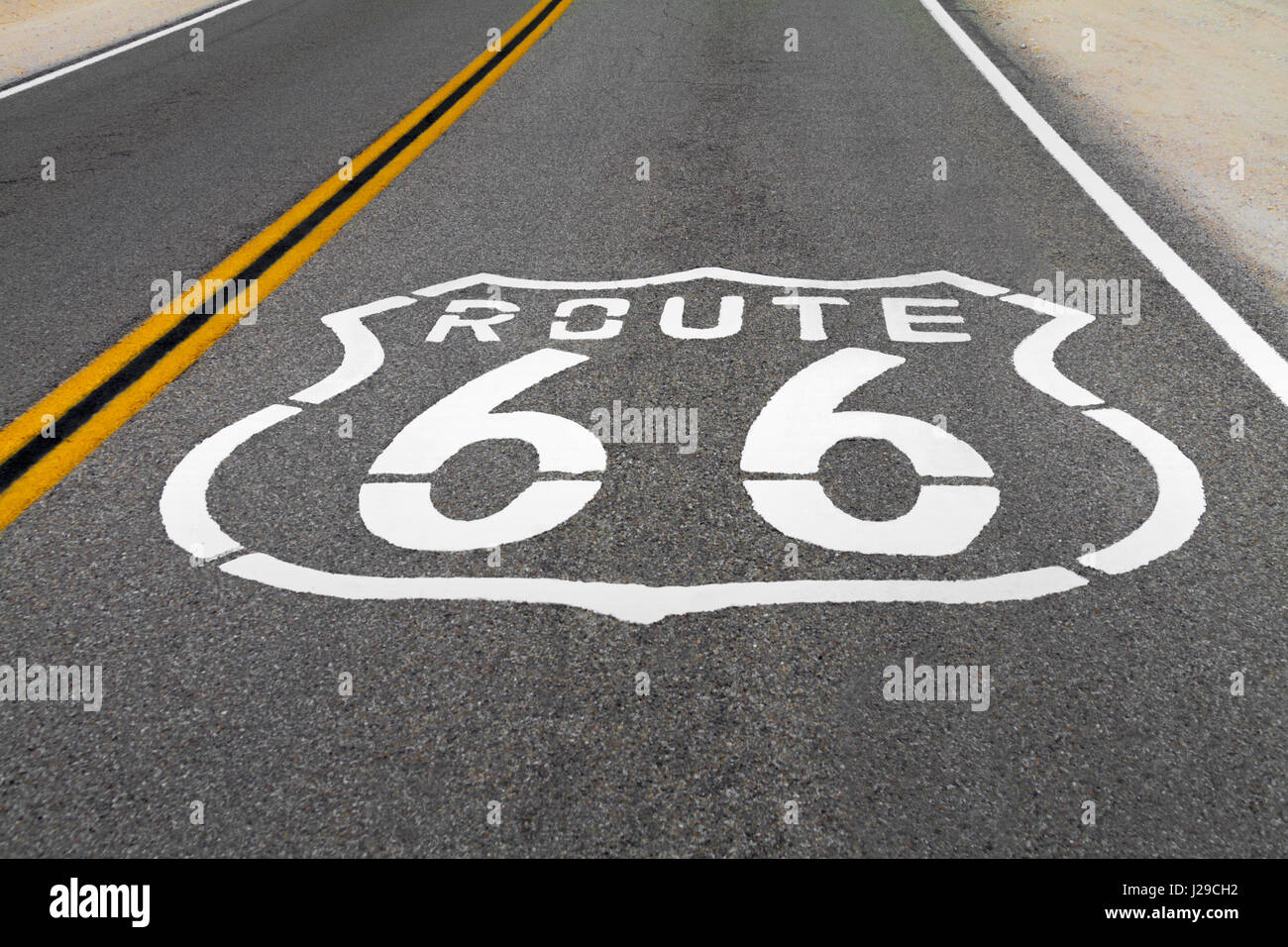 Le logo Route 66 sur le sol de la route avec deux lignes jaunes. Banque D'Images