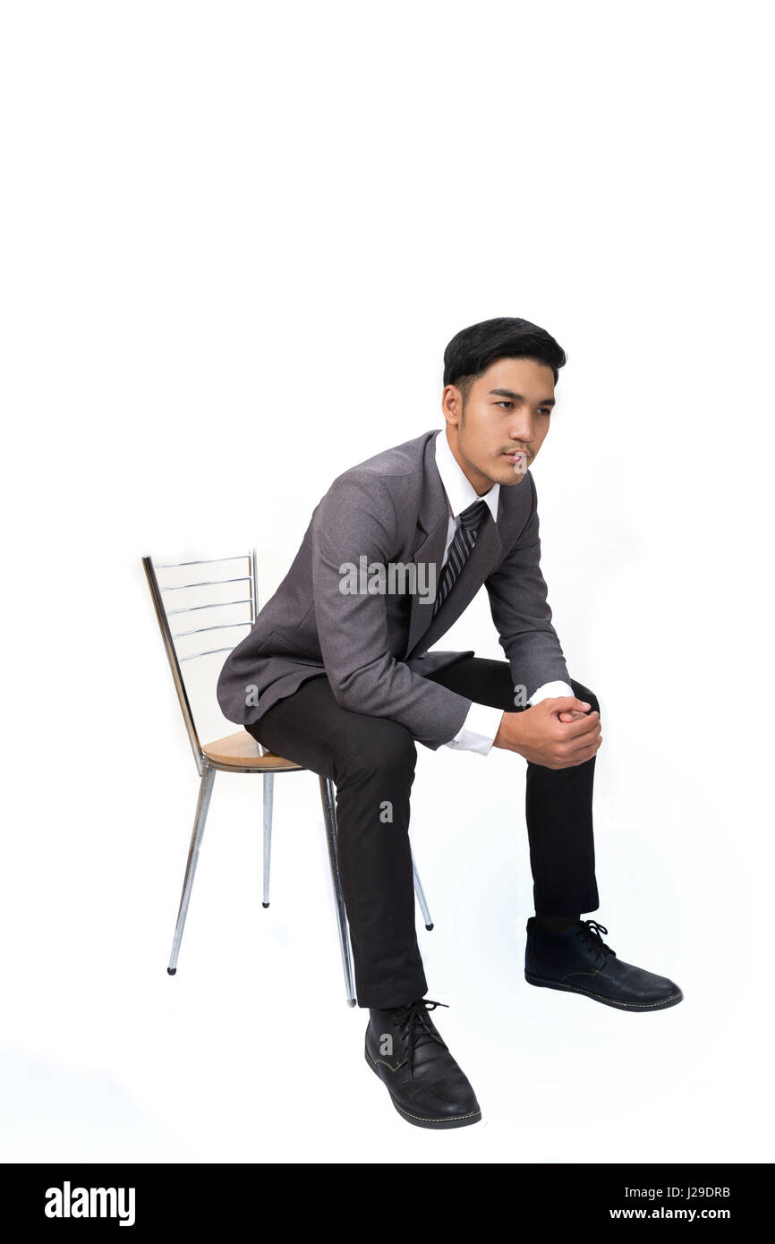 Jeune asiatique beau mâle startup entrepreneur Businessman wearing costume gris assis sur une chaise et de penser sur fond blanc Banque D'Images