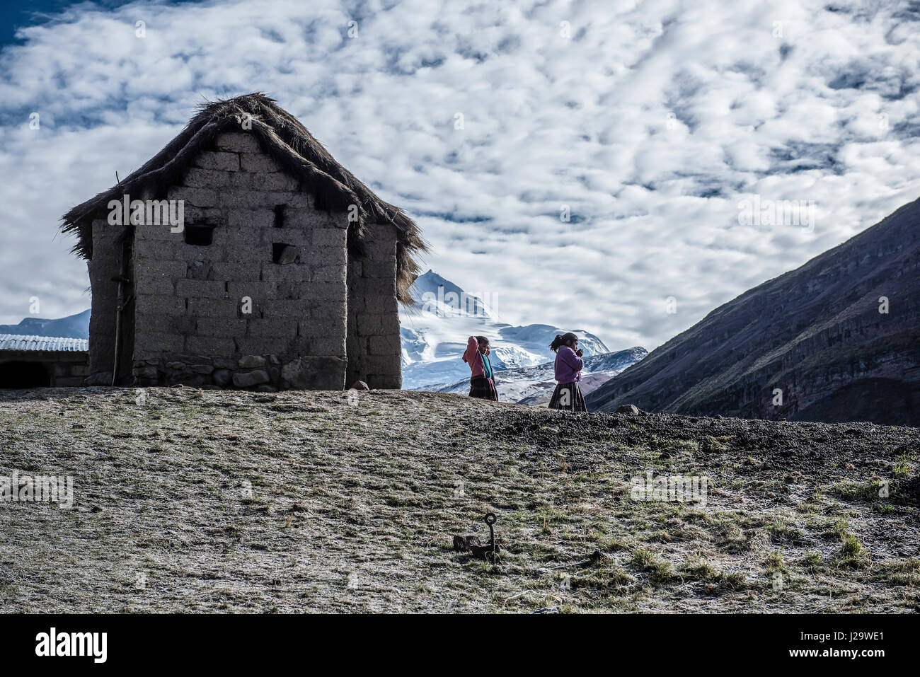 Deux petites filles sur les montagnes péruviennes (4,100 au-dessus du niveau de la mer) dans un froid jour de mai. En raison bambine sulle montagne une peruviane (4,100 mt slm) dans Una giornata fredda di Maggio. Banque D'Images
