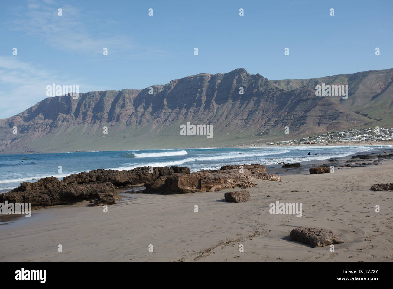 Les surfeurs attendent la vague parfaite à Famara, Lanzarote. Banque D'Images