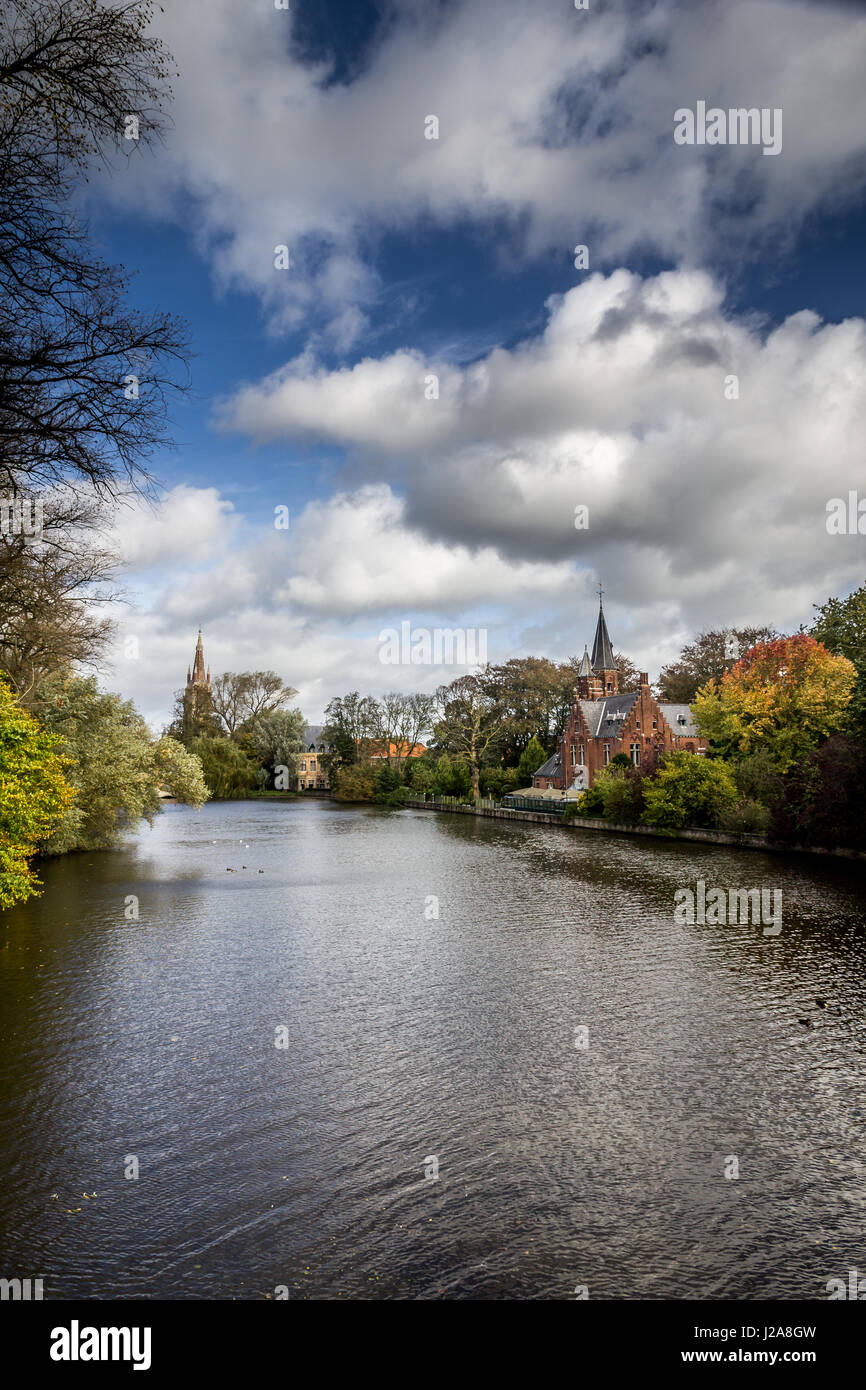 Lac romantique Minnewater à l'automne, avec sa célèbre maison de tours et de l'église de Notre Dame à Bruges, Belgique. Vue verticale. Banque D'Images