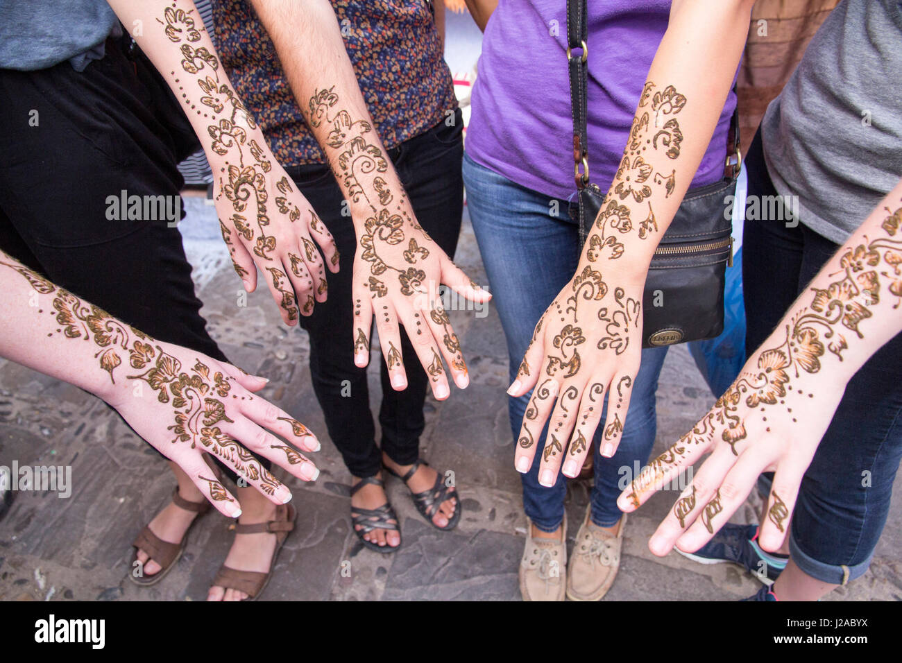 Le Maroc, Marrakech, Medina, le Souk de henné, de feuilles de henné et la masse de l'usine Poudre de henné et appliquée dans l'art populaire de conceptions pour les touristes les mains et les bras. Banque D'Images