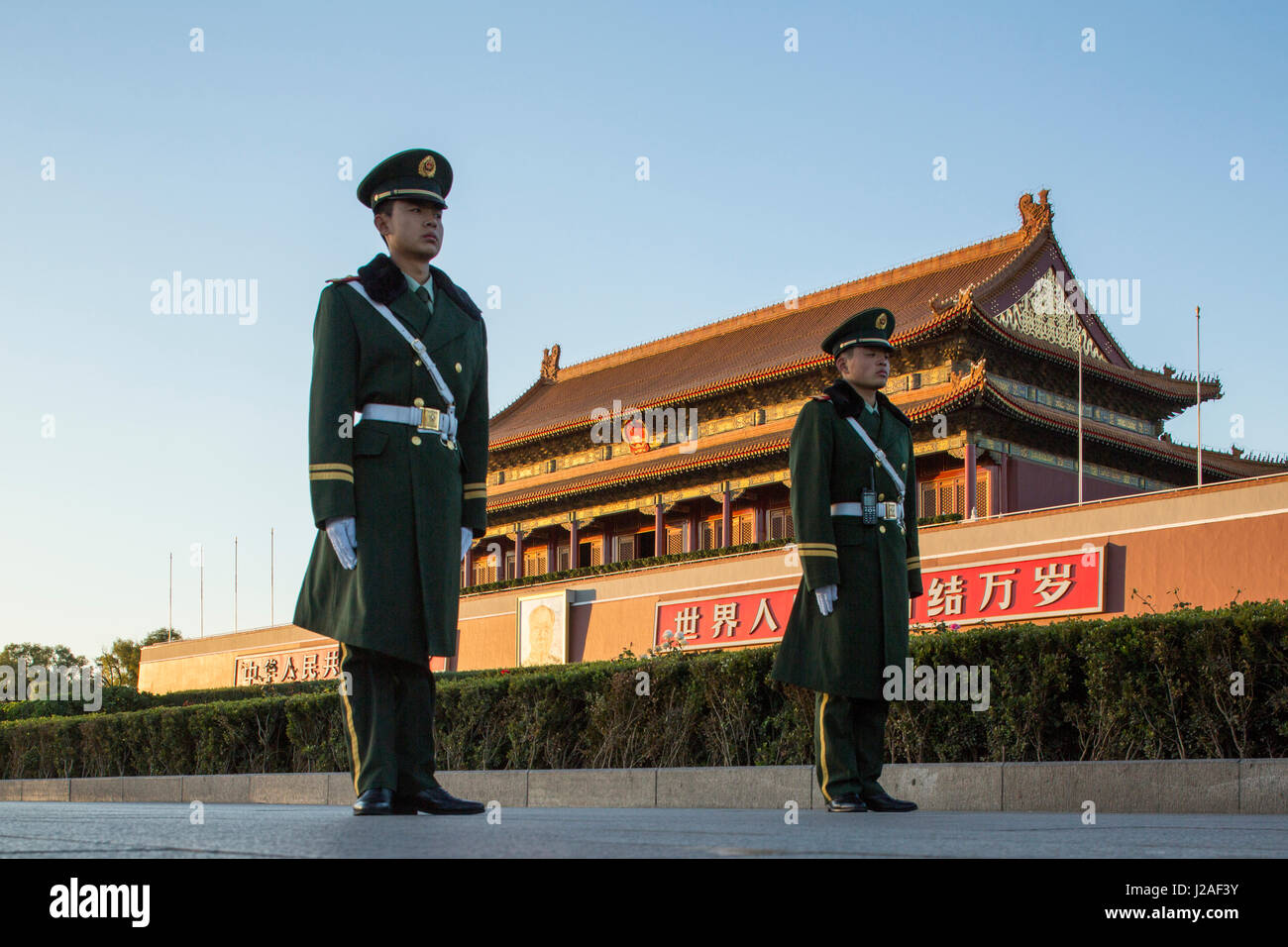 La Chine, Pékin, l'établissement de garde de la police militaire les rétroéclairages sun au garde à l'extérieur de la Cité Interdite pendant la descente de cérémonie du drapeau chinois sur la place Tiananmen Banque D'Images