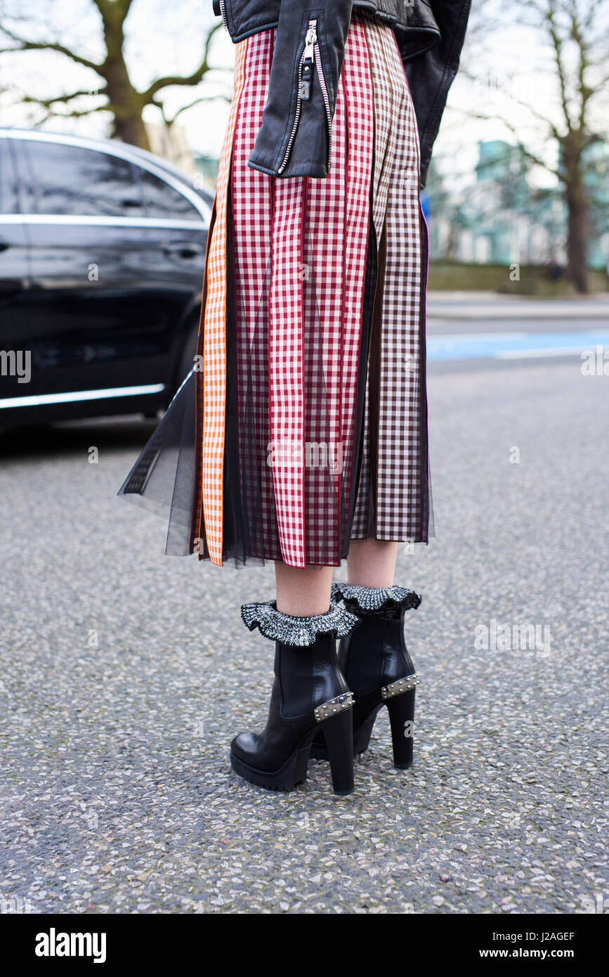 Londres - Février 2017 : faible section of woman wearing high heeled boots et jupe plissée sur le champ lors de la London Fashion Week, vertical, vue arrière Banque D'Images