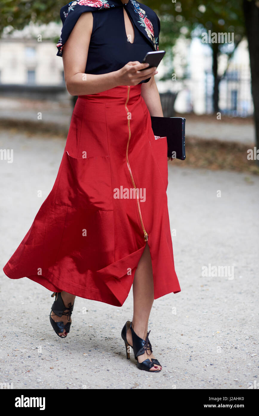 Femme en longue jupe rouge marche dans street en utilisant le téléphone,  petit Photo Stock - Alamy