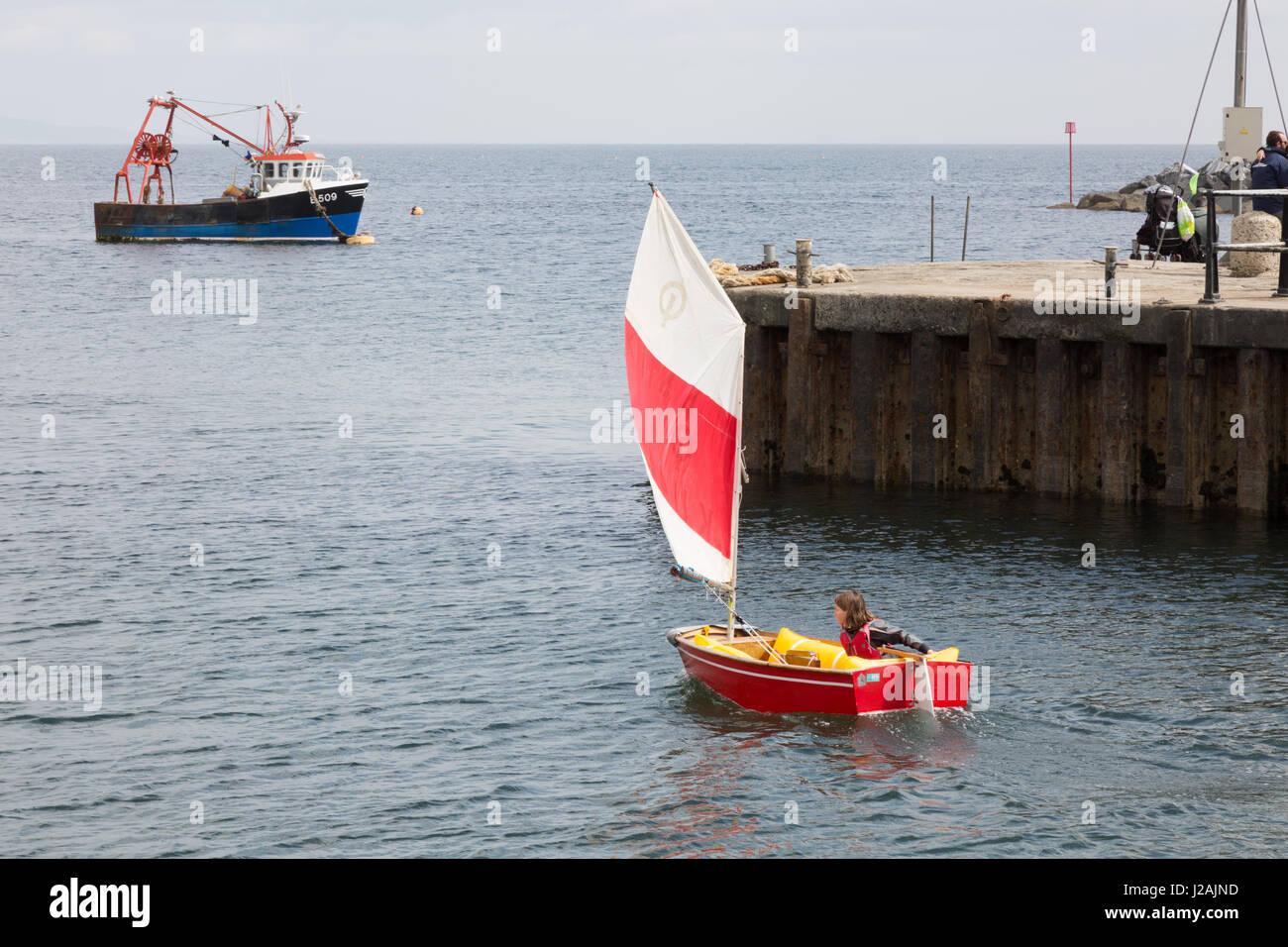 À l'enfant un optimiste canot , port de Lyme Regis, dans le Dorset UK Banque D'Images