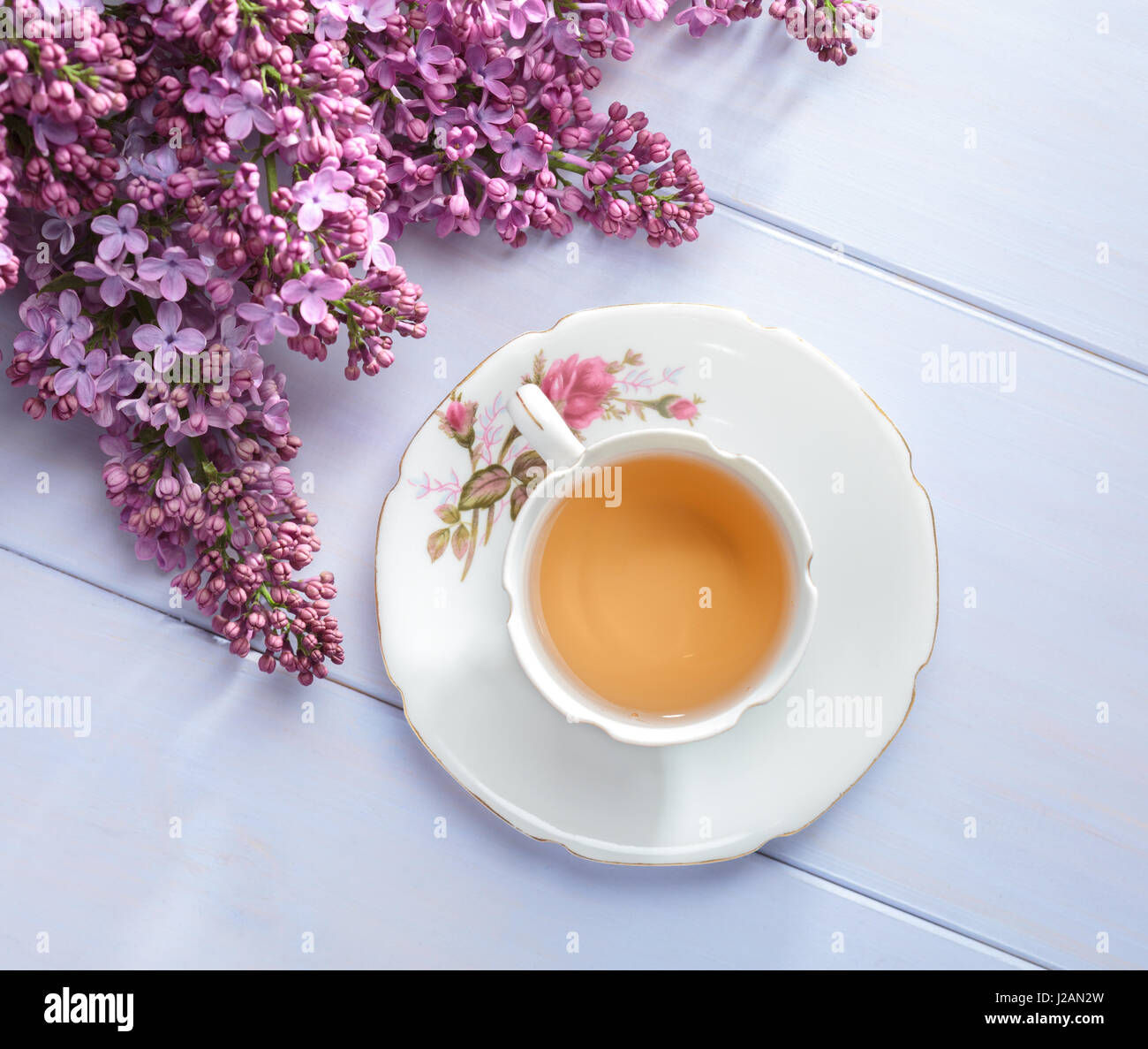 Tasse de thé et des branches de lilas en fleurs sur table en bois. Banque D'Images