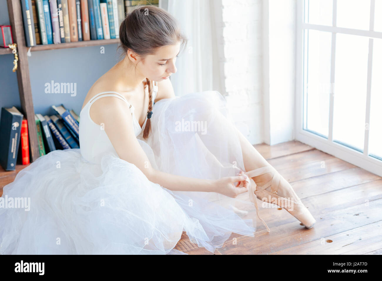 Chaussons de ballet danseuse attachant autour de sa cheville femme Ballerine pointe. Banque D'Images