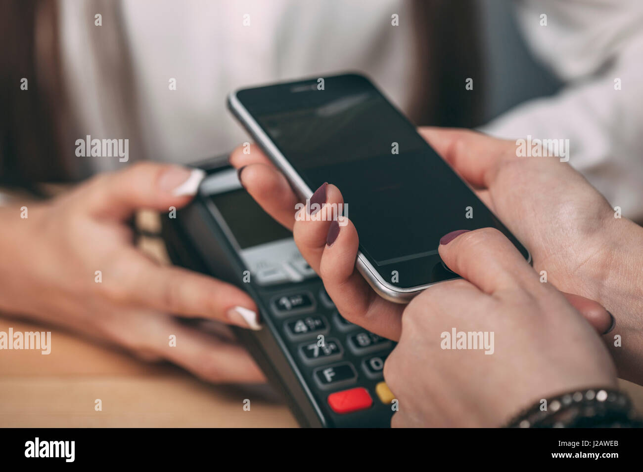 Détail image de la femme à l'aide de smart phone à payer au comptoir Banque D'Images