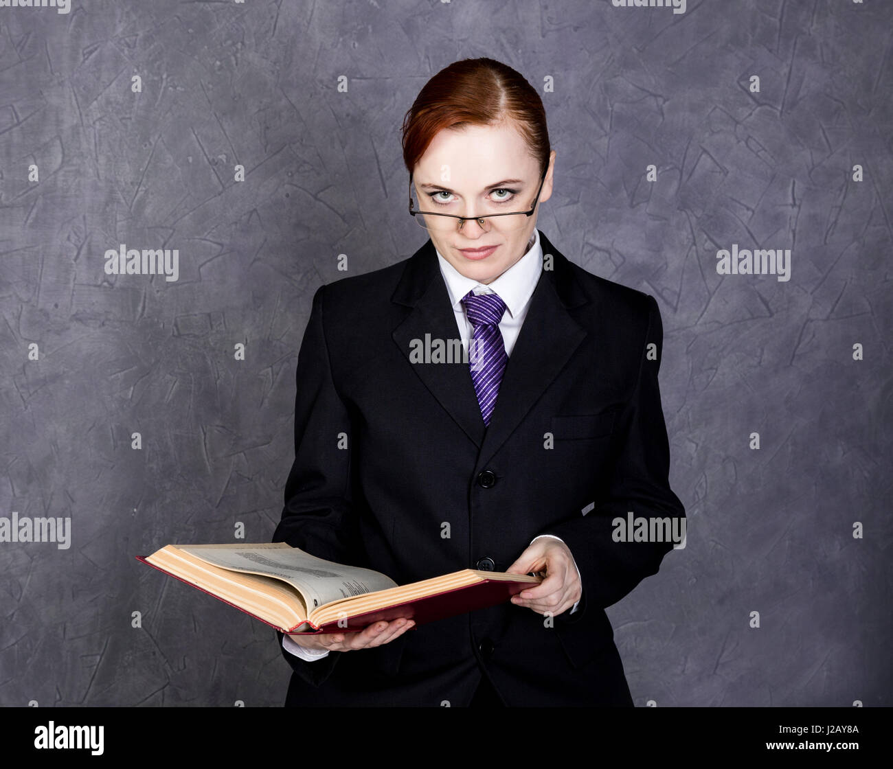 Avocate lit un gros livre avec sérieux, femme d'un homme en costume, cravate  et lunettes Photo Stock - Alamy