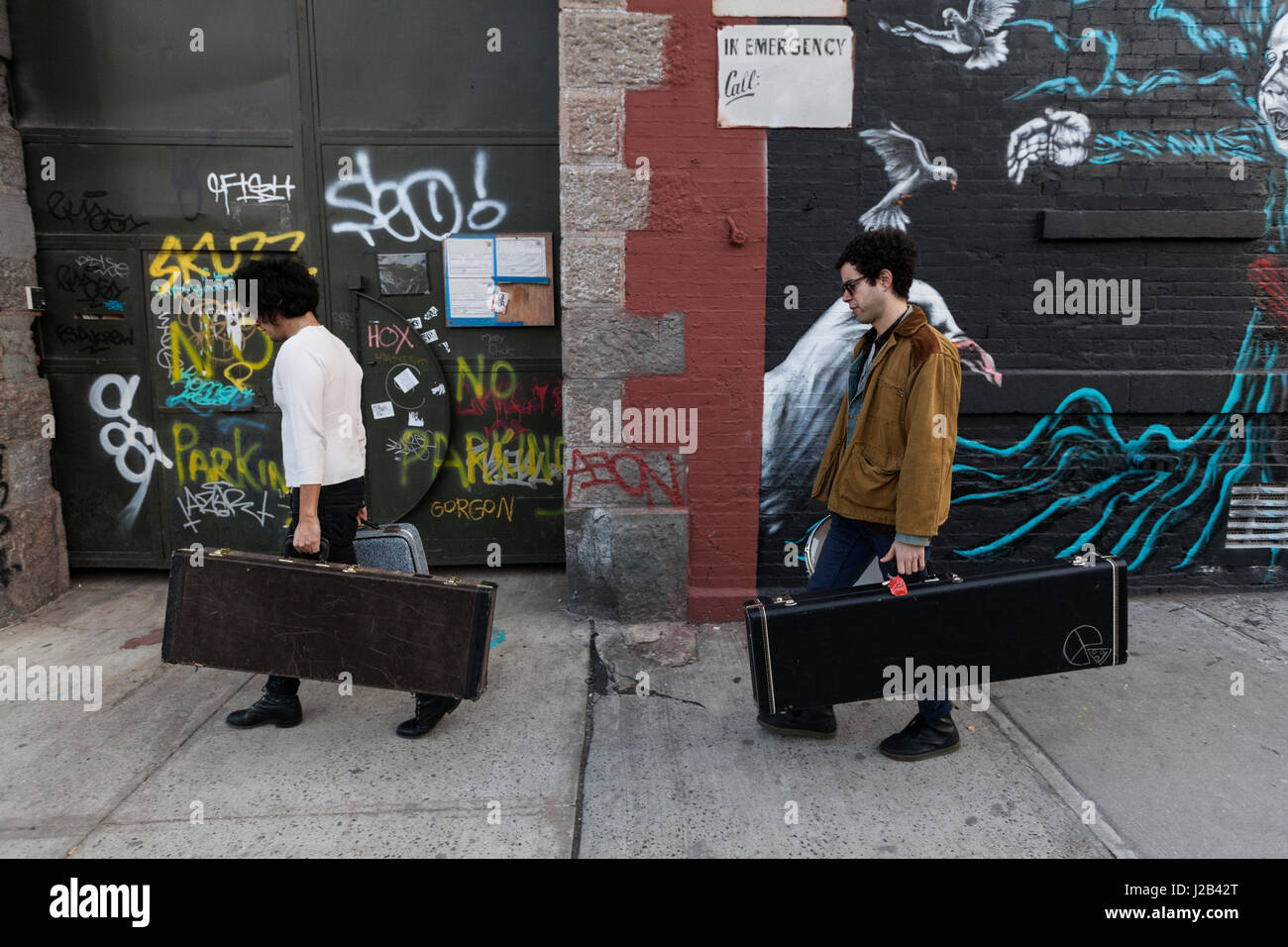 Les jeunes hommes portant leurs cas de guitare Banque D'Images