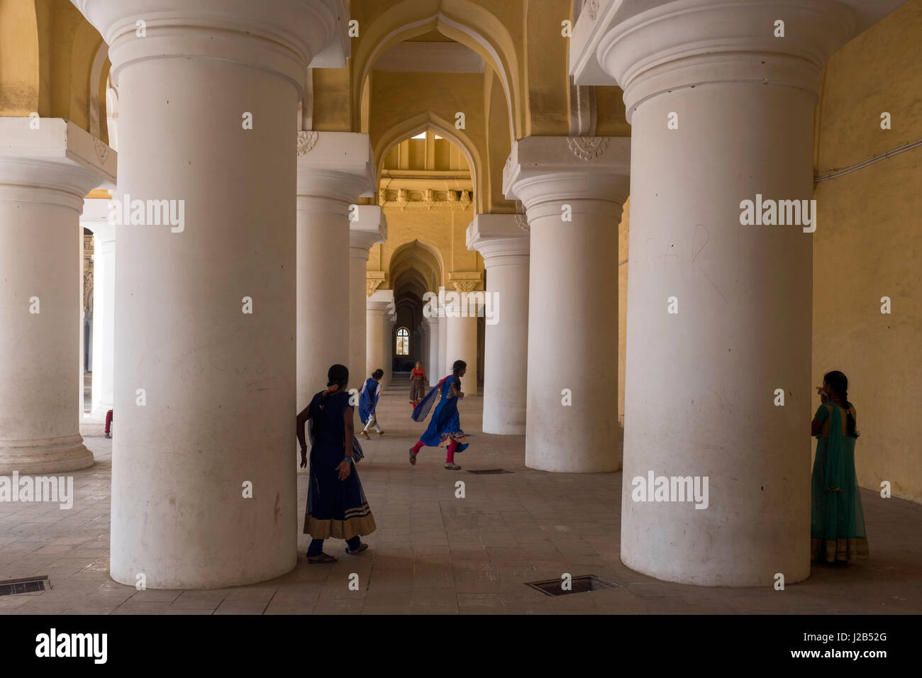 Un groupe de filles jouer entre les piliers de la Palais Thirumalai Nayakkar Mahal Banque D'Images