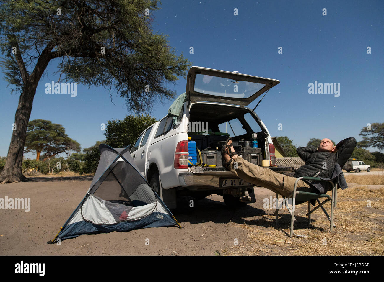 L'Afrique, Botswana, Chobe National Park, l'auto-portrait du photographe Paul Souders reposant par camion dans la région de Savuti Marsh camping Banque D'Images