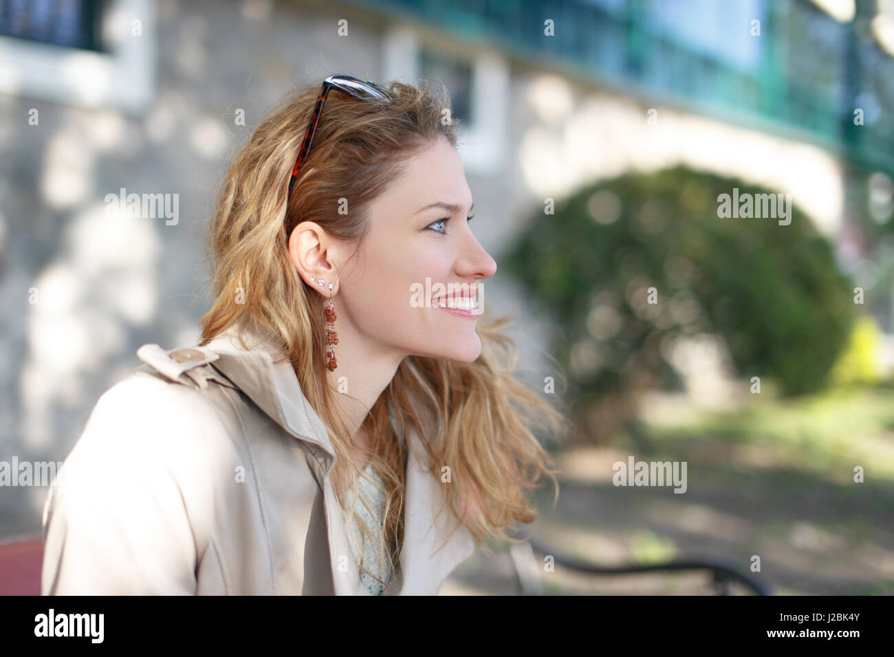 Belle jeune femme à la voiture en stationnement au portrait printemps Banque D'Images