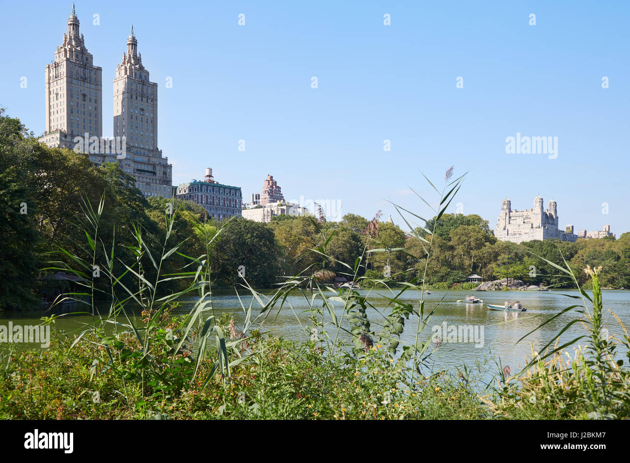 Étang de Central Park à New York avec des bateaux et le San Remo bâtiment dans une journée ensoleillée Banque D'Images