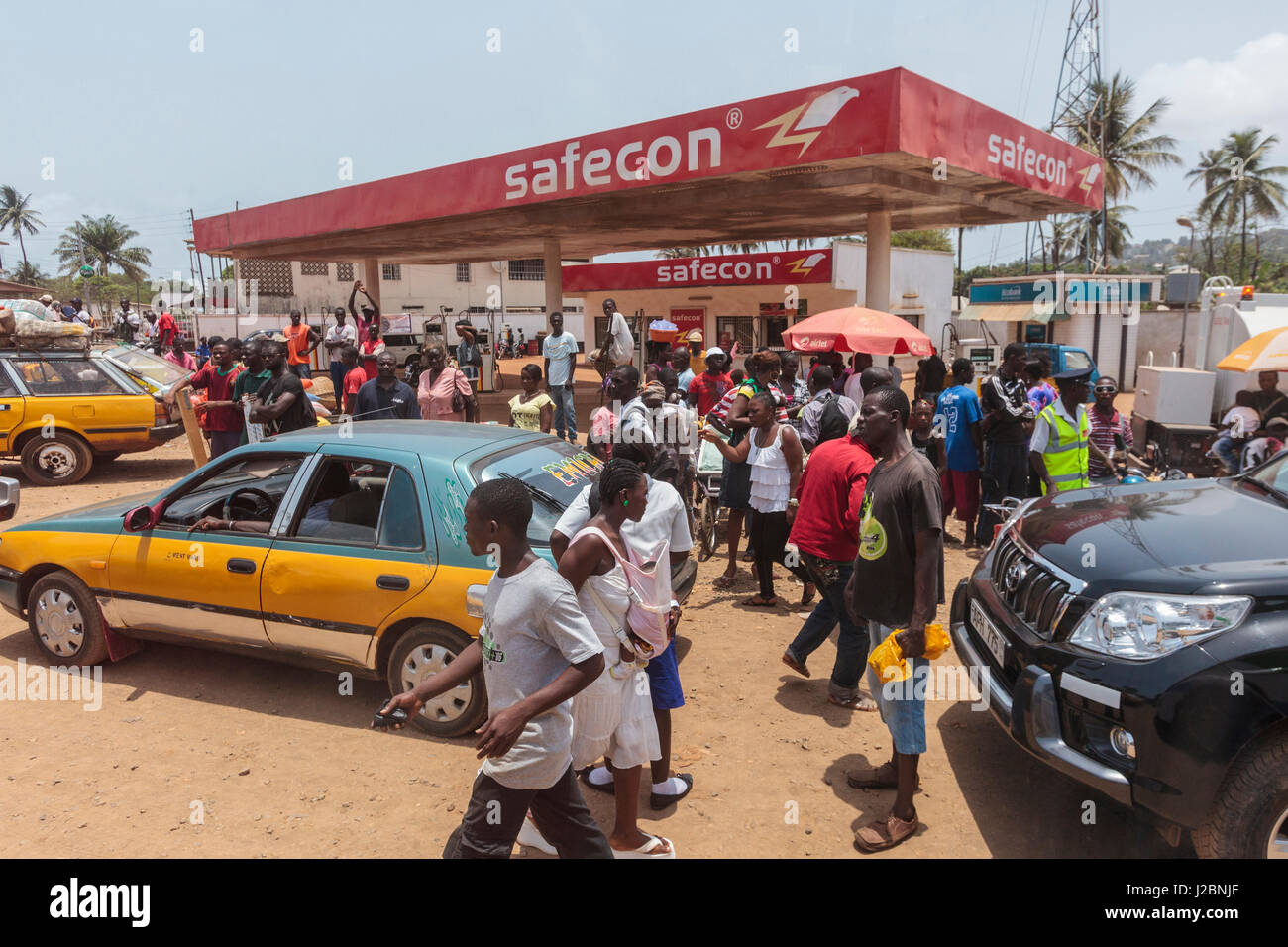 L'Afrique, Sierra Leone, Freetown. Les personnes en attente de transport à la station d'essence. Banque D'Images