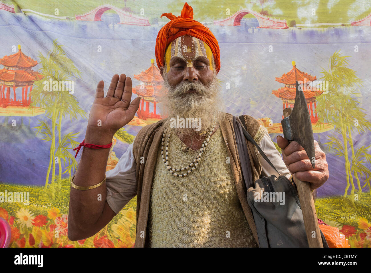 L'Inde, Sonepur, saint homme posant devant une peinture murale Banque D'Images