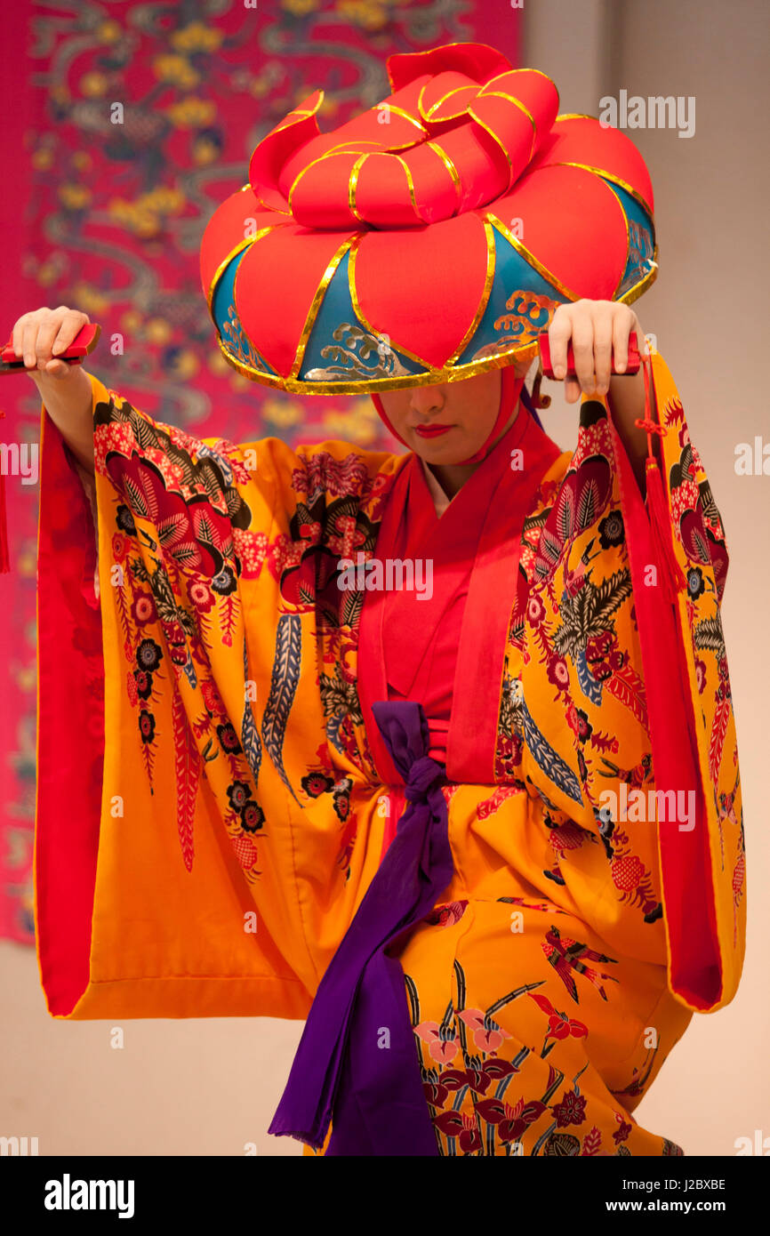Une danseuse en costume traditionnel exécute une danse d'Okinawa pour les visiteurs de la Ryukyu Mura, un parc à thème dédié à la célébration de l'ancienne culture d'Okinawa. Banque D'Images