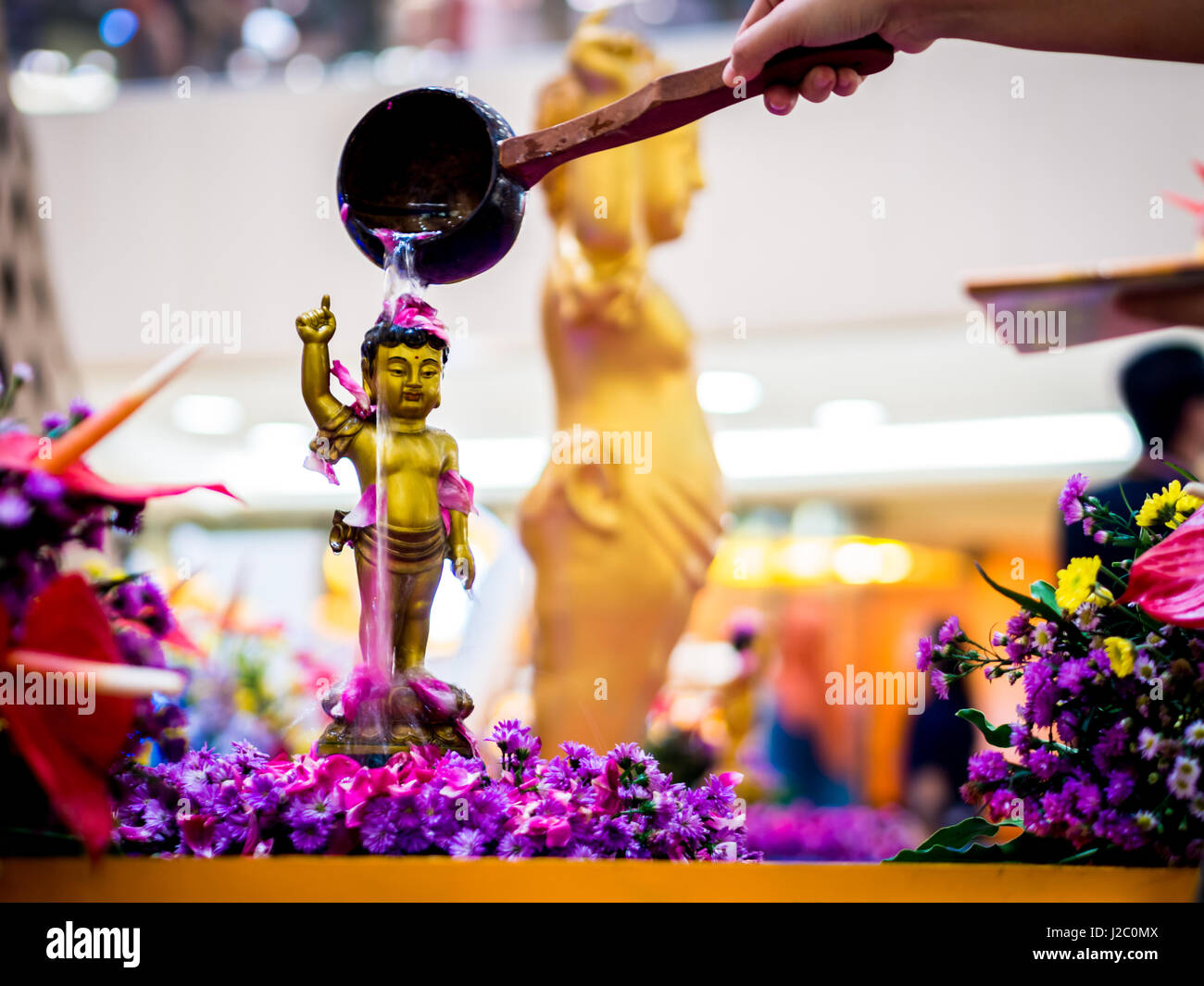 Siddhartha Gautama Buddha Sculpture rincé par l'eau et de fleurs Banque D'Images