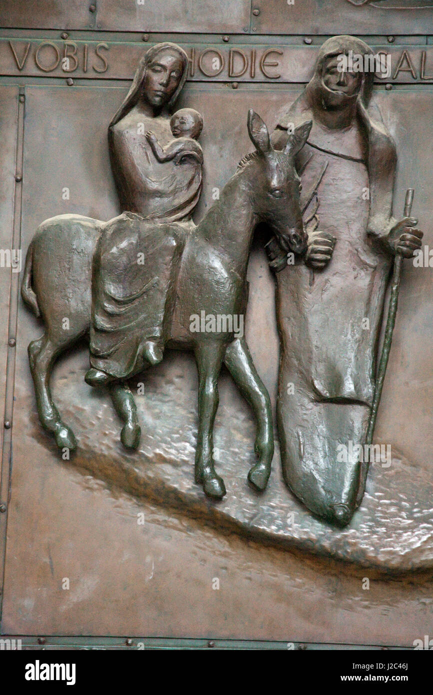 Soulagement de Bronze Marie, Joseph et Jésus enfant voyageant en Egypte pour échapper à la colère du roi Hérode sur la porte d'entrée de Nazareth basilique de l'Annonciation. Banque D'Images