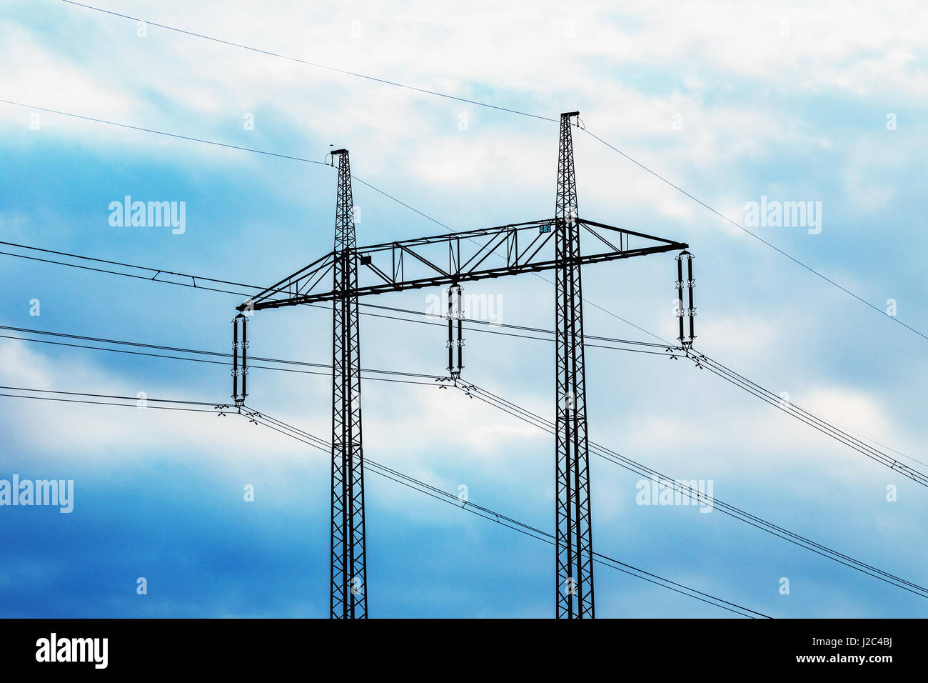 Pylône de transport d'électricité silhouetté contre le ciel bleu au crépuscule Banque D'Images