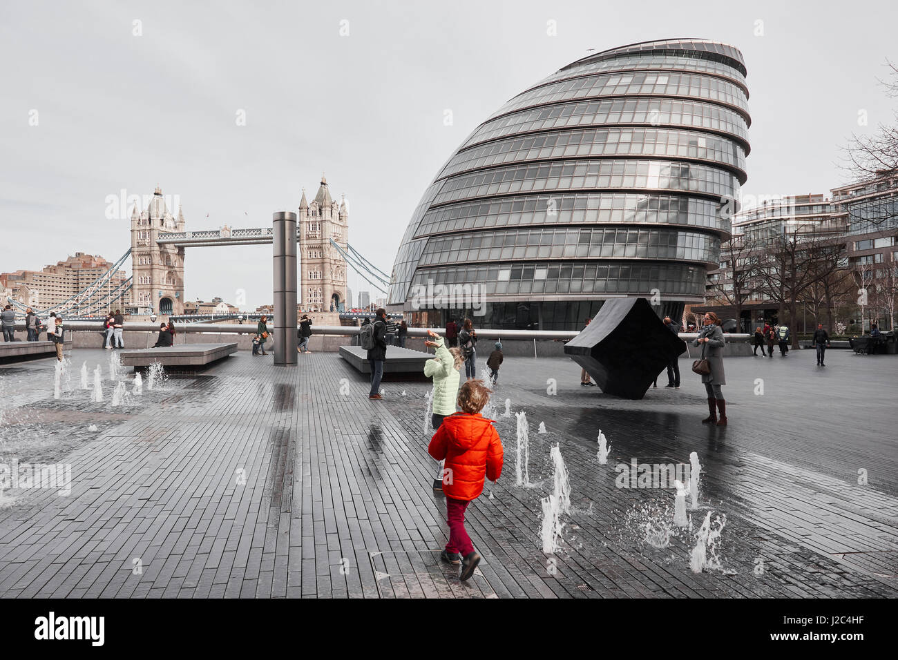 Enfants jouant dans les fontaines, plus de Londres, Tower Bridge et le City Hall, South Bank, Londres, Angleterre Banque D'Images