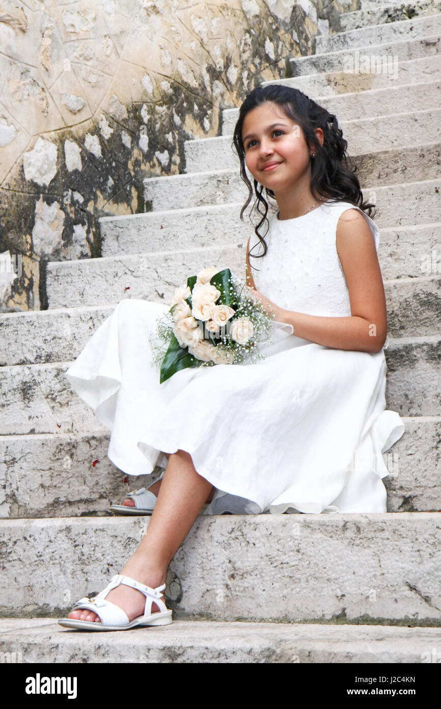 Souriante jeune fille en robe blanche pour la première Communion Photo  Stock - Alamy