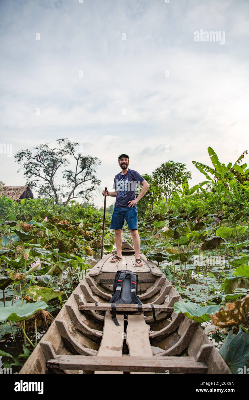 Bùi Hữu Cồn Sơn, près de Cần Thơ Nghĩa, capitale et plus grande ville du Delta du Mékong. Avec le bateau à rames à travers les plantations de la ferme piscicole. Banque D'Images
