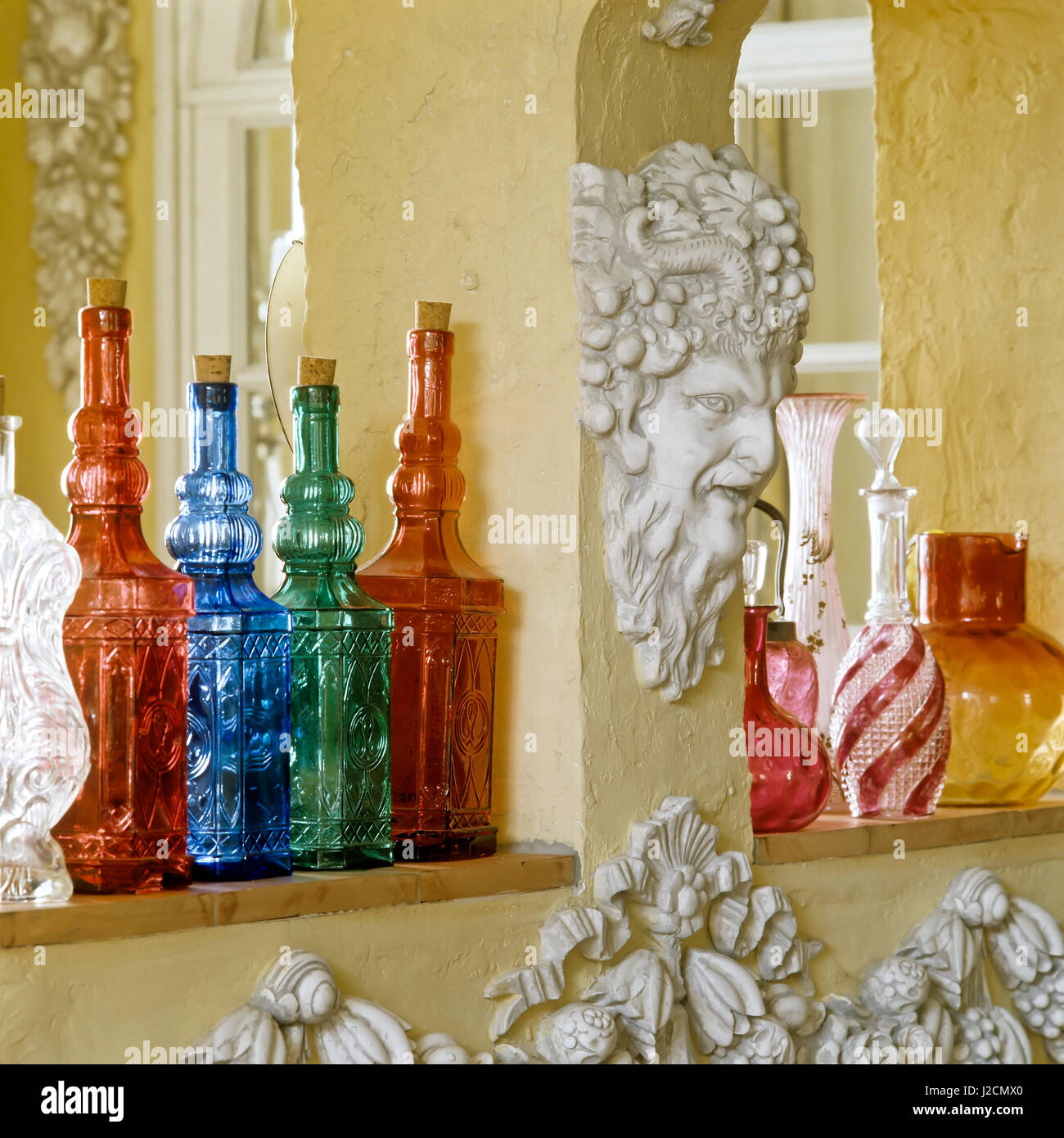 Bouteilles colorées à côté de la sculpture. Banque D'Images